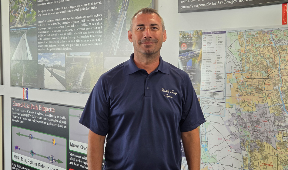 Adam Fowler standing in front of a map